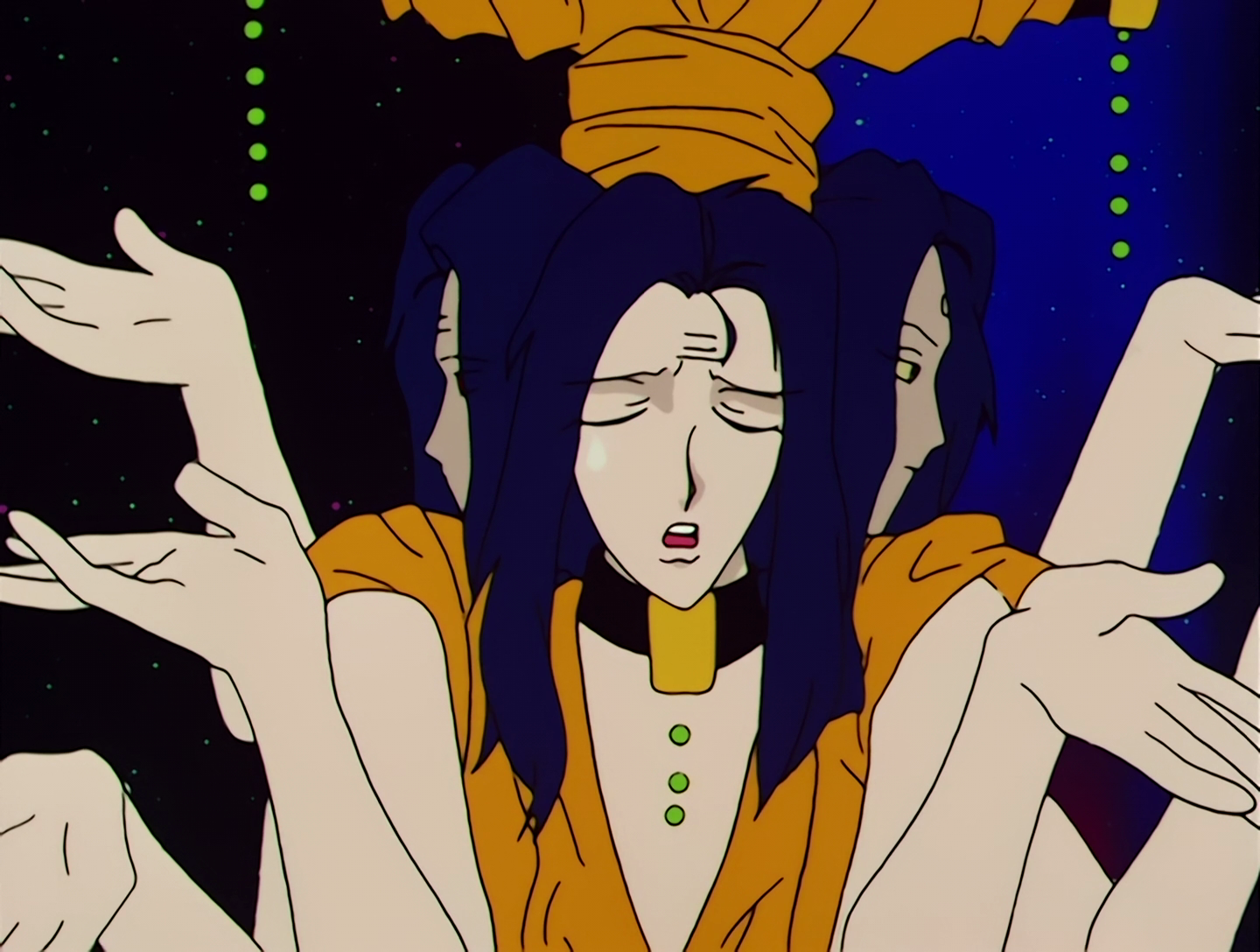 Yamandakka in closeup, and we can see her multiple faces. There are four in total, but we can only see three of them here as they sort of wrap around her head. Each face has the kanji for a number on the forehead, and the face currently facing us has the kanji for 3. She’s shrugging.